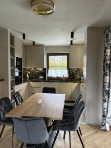 a kitchen with a wooden table and chairs at BABA JAGA na szlaku in Nowa Słupia +20 photos