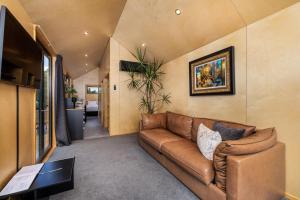 a living room with a couch and a tv at Tiny on Access in Kerikeri