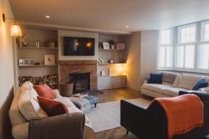 a living room with two couches and a fireplace at Luxury House sleeps 14 with Secret Bar near Bath in Warminster