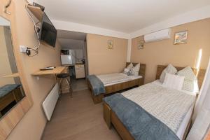 a small room with two beds and a desk at Matrakapuvendeghaz in Mátraszőlős