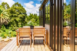 a wooden table and chairs on a deck at Tiny on Access in Kerikeri