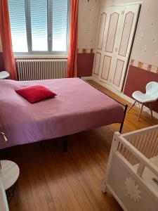 a bedroom with a large bed with a pink blanket at Agréable maison in Pons