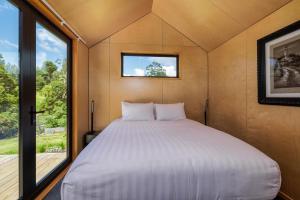 a bed in a small room with a window at Tiny on Access in Kerikeri