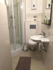 a bathroom with a shower and a toilet and a sink at City Apart Düss in Düsseldorf