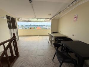 a dining room with tables and chairs and a window at Hostal Posada Del Sol in Guayaquil