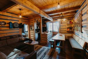 a living room in a log cabin with a couch and tables at Granddrevenica in Malá Franková