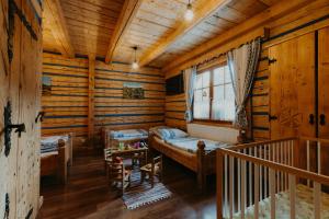 a room with two beds in a log cabin at Granddrevenica in Malá Franková