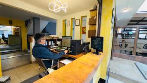 a man sitting at a desk in front of a computer at Hotel estación Kristal - Corferias in Bogotá +25 photos