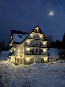 a lit up building in the snow at night at Willa Nosalowa Dolina in Zakopane