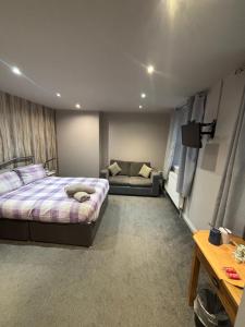 a bedroom with a bed and a couch at Airport Tavern Accommodation in Felton