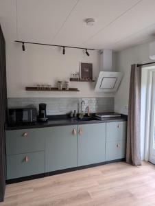 a kitchen with blue cabinets and a counter top at Bed and Breakfast Bergs Huuske in Sint Odiliënberg +15 photos