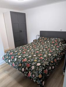 a bedroom with a bed with a floral bedspread at Bed and Breakfast Bergs Huuske in Sint Odiliënberg