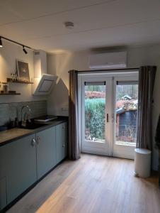 a kitchen with a large sliding glass door at Bed and Breakfast Bergs Huuske in Sint Odiliënberg