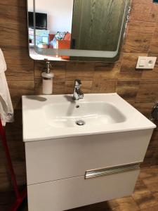 a white bathroom sink with a large mirror at Budha house in Lošonec +9 photos