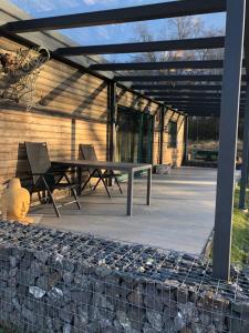 a patio with a table and chairs under a pergola at Budha house in Lošonec
