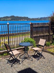 a table and two chairs sitting next to a fence at Casa Chiloe hostel in Castro