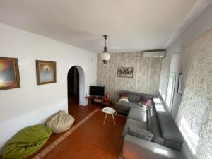 a living room with a couch and a tv at La Marciana - piscina pista tenis futbol y baloncesto privado - Bungalow externo independiente in Chiclana de la Frontera