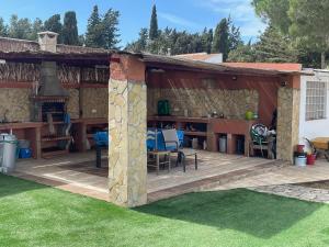 a pavilion with a table and chairs in a yard at La Marciana - piscina pista tenis futbol y baloncesto privado - Bungalow externo independiente in Chiclana de la Frontera