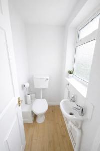 a white bathroom with a toilet and a sink at Daisy House- Sleeps 7- Driveway Parking, Contractors, Fast Wifi and Smart TV in Oxford +17 photos