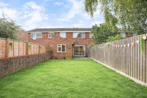 a backyard of a brick house with a fence at Daisy House- Sleeps 7- Driveway Parking, Contractors, Fast Wifi and Smart TV in Oxford