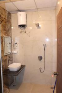 a bathroom with a shower with a toilet and a sink at Hotel Nirmal Bhawan Haridwar in Haridwār