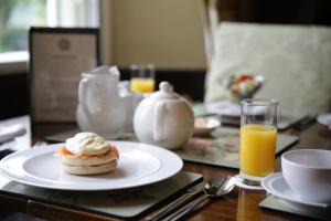 una mesa con un plato de repostería y un vaso de zumo de naranja en Walker Ground Manor, en Hawkshead