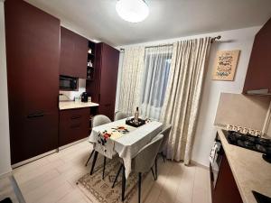 a small kitchen with a table and a kitchen with a stove at Hils Pallady in Bucharest