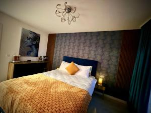 a bedroom with a bed with a blue headboard and a chandelier at Hils Pallady in Bucharest