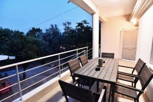 a balcony with a wooden table and chairs and a view at Adams Suites in Paleo Tsifliki