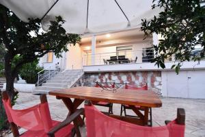a wooden table and chairs in front of a building at Adams Suites in Paleo Tsifliki