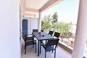 a dining room table and chairs on a balcony at Adams Suites in Paleo Tsifliki