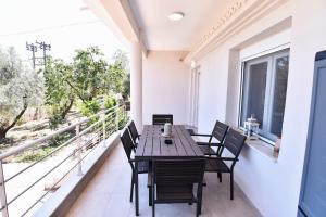 a balcony with a wooden table and chairs at Adams Suites in Paleo Tsifliki +77 photos