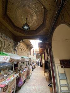 ein Gang in einem Laden auf einem Markt, in dem sich Menschen befinden in der Unterkunft Riad Dalal in Fès