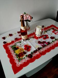 a table topped with a bottle of champagne and flowers at ELIZA's HOUSE in Petroşani +13 photos