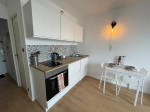 a kitchen with a stove and a table with chairs at Calais plage, superbe studio tout confort in Calais