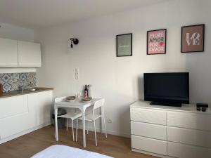 a living room with a small table and a television at Calais plage, superbe studio tout confort in Calais