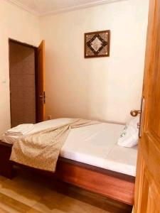 a bedroom with a bed with a wooden frame at appartment émeraude in Kribi