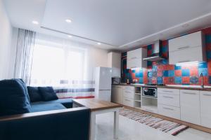 a kitchen with a couch and a table in a room at Apart Lawina in Sumy