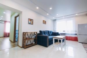 a living room with a blue couch and a table at Apart Lawina in Sumy