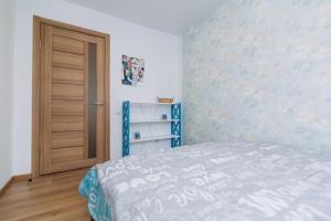 a bedroom with a bed and a wooden door at Apart Lawina in Sumy
