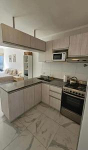 a kitchen with a stove and a microwave in it at Apartamentos del campus in Presidente Derqui