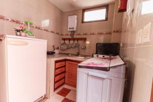 a small kitchen with a stove and a refrigerator at Appartement calme et ensoleillé avec WiFi haut débit in Sidi Ifni