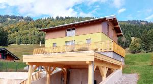 a house with a deck on top of it at Alpenrose Ferienwohnung in Balderschwang