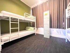 a room with two bunk beds and a closet at Utopia31 Hostel - formerly Frienz Backpacker in Auckland