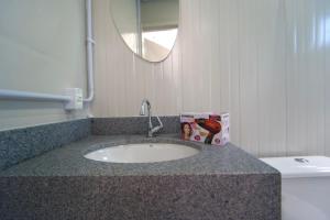 a bathroom counter with a sink and a toilet at Villammare Cachoeira in Florianópolis +24 photos