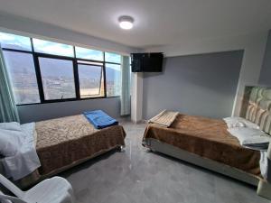 a bedroom with two beds and a large window at Mishki Punuy in Caraz