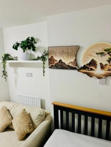 a bedroom with a bed and a plant on the wall at Lakes Guest Room Annexe in Penrith