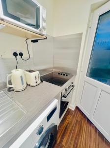 a small kitchen with two toasters on a counter at Lakes Guest Room Annexe in Penrith