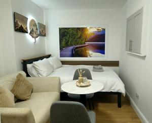 a room with a bed and a couch and a table at Lakes Guest Room Annexe in Penrith
