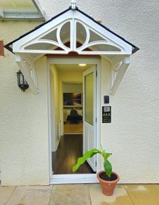 an open door of a house with a potted plant at Lakes Guest Room Annexe in Penrith +3 photos